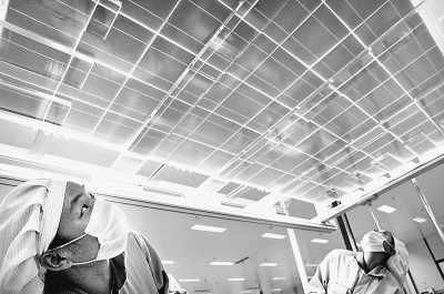 江蘇一家能源公司的工人在檢查出口太陽(yáng)能光伏電池組件。 　　CFP供圖